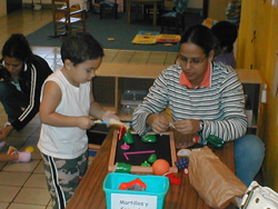 Meastra y niño trabajando con objetos diversos